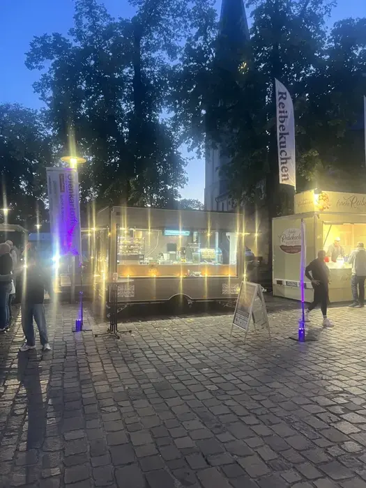 Beleuchteter Foodtrailer bei Nacht auf einem Marktplatz