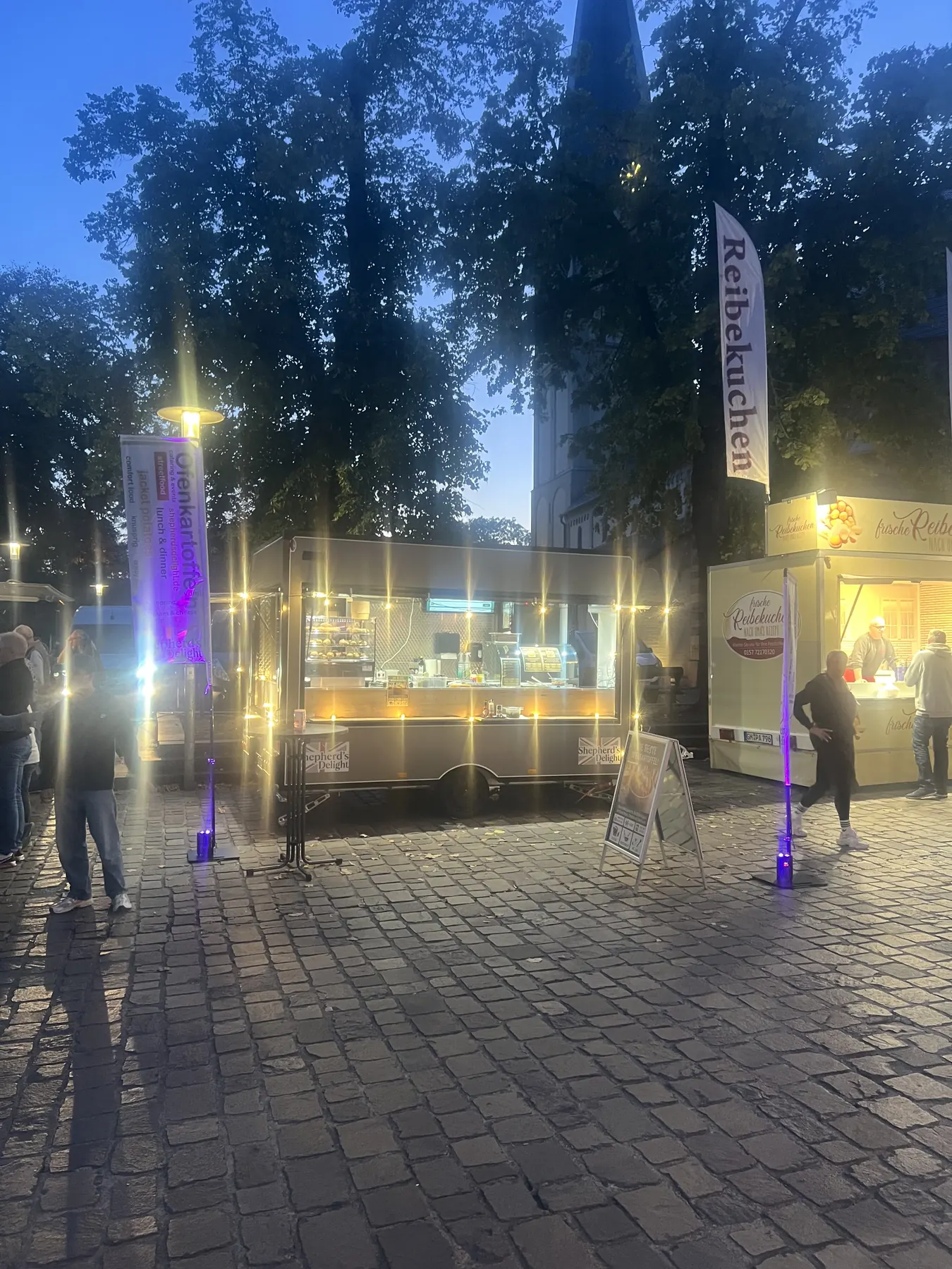 Beleuchteter Foodtrailer bei Nacht auf einem Marktplatz