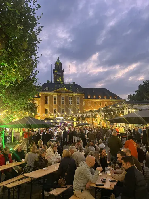 Volle Biertischgarnituren bei Abendstimmung vor dem Rathaus Herne beim Stadtfest Herne Mittendrin
