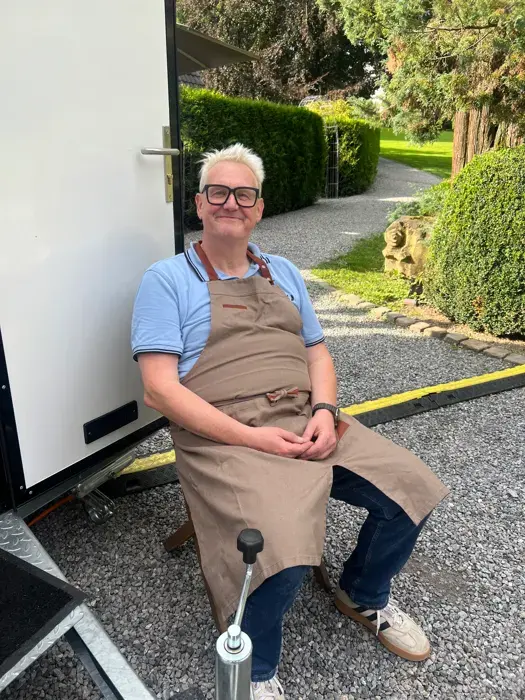 Michael in Schürze vor der geöffneten Tür des Shepherd's Delight Foodtrailers
